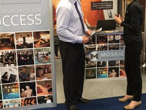Mosaic's stand with a client visiting